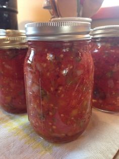 three jars filled with food sitting on top of a table