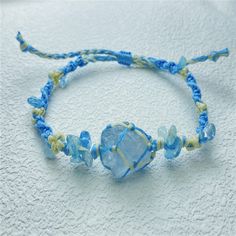 a blue and yellow beaded bracelet with glass beads on a white cloth covered surface