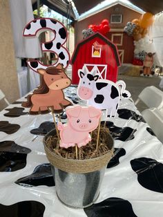 there are farm animals on sticks in the center of a table with black and white polka dots