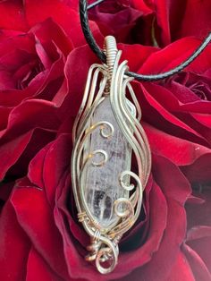 Handmade with Graceful curves of silver plated wire that envelop a Quartz crystal, this beautiful pendant hangs on a 20" Black Cord Necklace. Each pendant comes in a free gift box ready for presentation. Quartz is thought to Clear and activate all of the Chakras, considered the Master Healer, Can offer Powerful Protection. Amplify Energy, Aid in Concentration and Memory. Can help balance your entire energetic system.     Silver is associated with the crown chakra. raising sensitivity, expanding awareness, enhancing intuition, and increasing compassion. People who wear silver enjoy improved dreams, love, protection, and better brain function. Copper fills the core which is thought to conduct energy, clear out negativity, and to help balance the chakras. Makes a wonderful Valentine's Day gif Unique Hand Wrapped Crystal Necklace, Artistic Hand Wrapped Jewelry For Gifts, Artistic Hand Wrapped Jewelry Gift, Artisan Wire Wrapped Crystal Necklace As Gift, Artisan Silver Wire Wrapped Crystal Necklace, Artisan Wire Wrapped Crystal Necklace For Gifts, Handmade Spiritual Crystal Necklace For Wedding, Pendant Necklace Silver, Brain Function