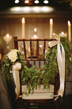 a chair decorated with greenery and white roses