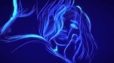 a woman's face is lit up with blue light in the dark, while her hair is blowing in the wind