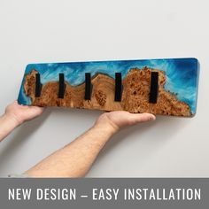 a hand holding a wooden board with four black magnets on it and the text new design - easy installation