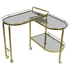 a gold metal and glass serving table with wheels