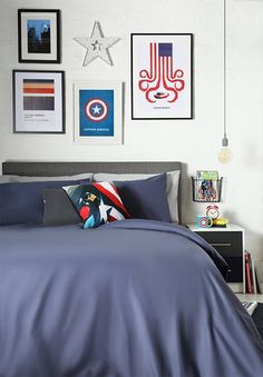 a bedroom with blue sheets and pictures on the wall