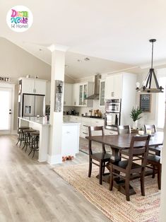 a dining room and kitchen area in a home with hardwood floors, white cabinets, and an open floor plan