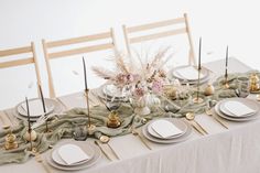 the table is set with plates, silverware and napkins for an elegant dinner