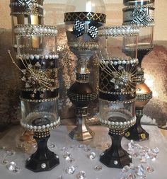 three glass vases with pearls and bows on them