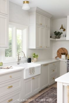 a kitchen with white cabinets and gold hardware on the handles, counter tops and drawers