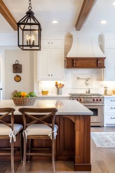 a kitchen with an island and two chairs at the table in front of the sink