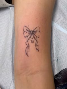 a small bow tattoo on the ankle