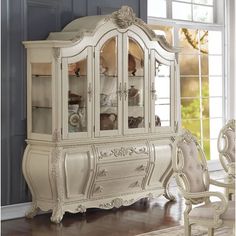 an ornate white china cabinet with glass doors