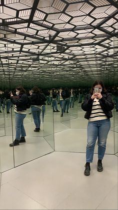 a woman taking a selfie in front of mirrors