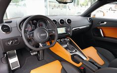 the interior of an automobile with orange and black leather