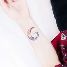 a woman's wrist with a wave tattoo on the left side of her arm