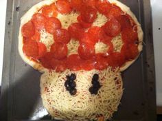 a pizza with pepperoni and black olives in the shape of a face on it