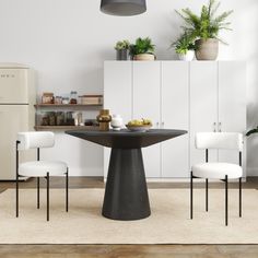 a black table and chairs in a white room