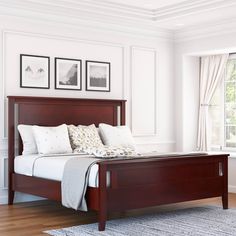 a bedroom with white walls and wood furniture