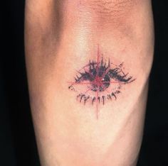 a tattoo on the leg of a person with an evil eye and words written below it