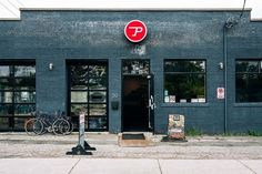 there is a parking meter in front of a building with bicycles parked outside the door