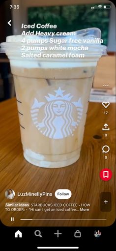 a cup of coffee sitting on top of a wooden table next to a cell phone