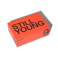 an orange box with the words still young written in black on it, against a white background