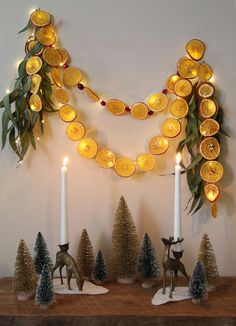 a mantle with candles and ornaments on it, including orange slices hanging from the mantel