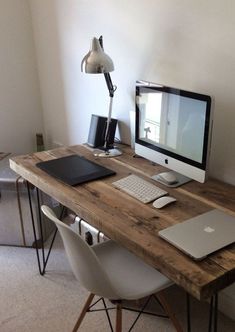 a wooden desk with a computer and laptop on it