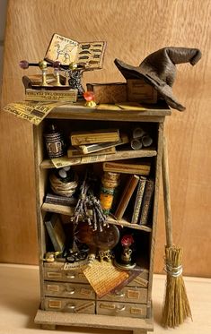 an old bookcase with books, hats and brooms on it's shelf