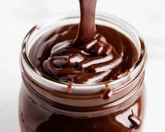 a jar filled with melted chocolate on top of a table