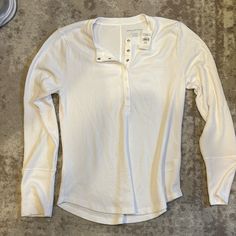 Xl White Long Sleeve Shirt, Half Snap Button On Front, Never Worn, Tags Still On! Overalls With Long Sleeve Shirt, Casual Long Sleeve Tops With Button Cuffs, Fall Henley Neckline Tops With Button Cuffs, White Cotton Henley With Buttons, Casual Long Sleeve Tops With Snap Buttons, Everyday Long Sleeve Henley With Button Closure, White Crew Neck Shirt With Buttons, Casual Long Sleeve Henley With Button Closure, White Henley Top For Fall