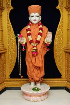 an image of a statue in the middle of a room that is decorated with flowers and garlands