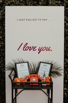 a sign that says i love you with two pictures on it and an orange telephone