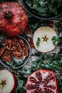 apples, pecans, and other fruits are arranged on a table with leafy greens