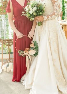 two brides standing next to each other holding bouquets in their hands and smiling at the camera