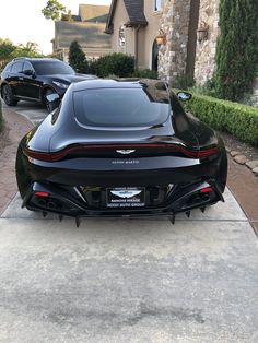 a black sports car parked in front of a house