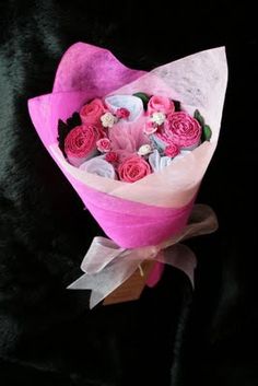 a bouquet of pink and white flowers on a black background