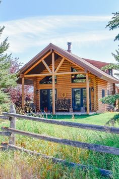 a log cabin sits in the middle of a field