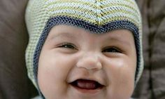 a smiling baby wearing a knitted hat