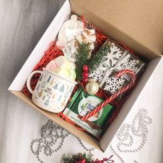 an open christmas gift box with coffee mug and other items