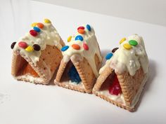 three pieces of cake with white frosting and multicolored candies on top