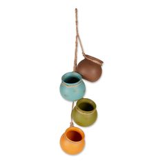 three ceramic vases hanging from a rope on a white background, each with different colors