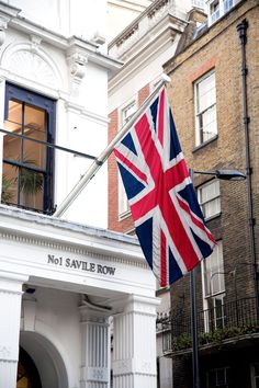 an union jack flag flying in front of a no1 save row building, london