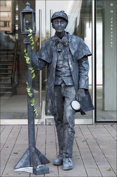 a statue of a man holding a lamp post