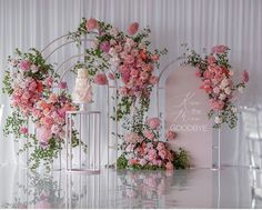 pink flowers and greenery decorate the backdrop for a wedding