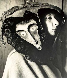 a woman wearing a hat with an animal's head on top of her face