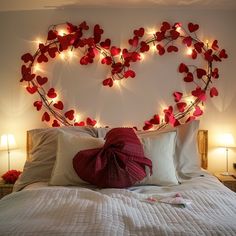 a heart - shaped bed with red hearts on the headboard and lights above it