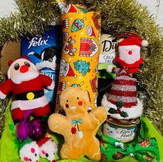 a basket filled with stuffed animals and other holiday items on top of a green cloth