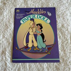 the disney book is laying on top of a white blanket with an image of two people hugging