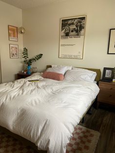 a white bed sitting in a bedroom next to a wooden dresser